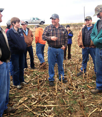 Mark Glawe speaks to a crowd at a field day in a grazed field of corn stubble cover crops