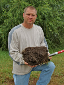 Doug Peterson holding soil sent by him