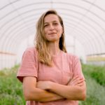 Anna Hankins poses in a high tunnel on her farm near Coggon, Iowa.