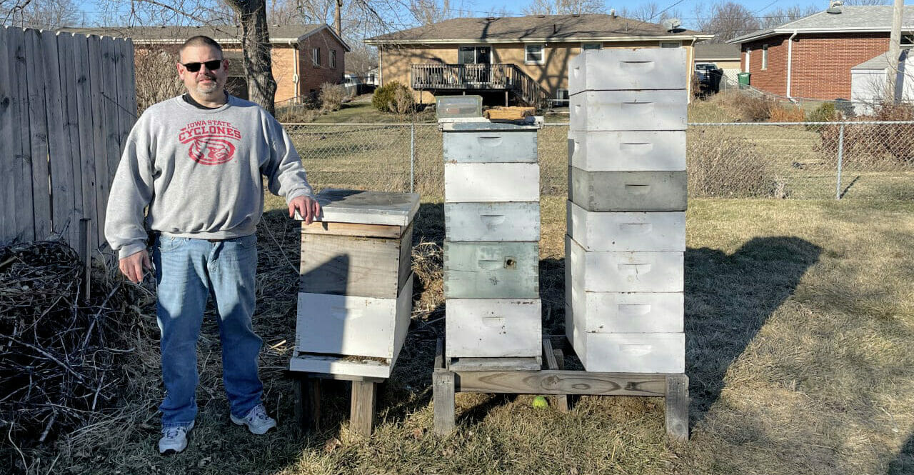 Dean Coleman standing by his bee hives.
