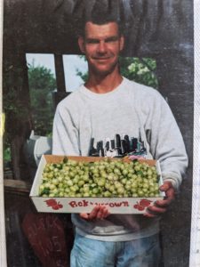 Mike Henry showing off giant gooseberries at Berry Patch Farm