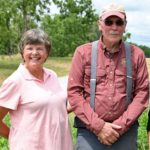 Nancy and John Brannaman smile for the camera outside on their farm. 