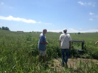 Russell Wischover and Bruce Carney look at one of the cow water sources on the farm