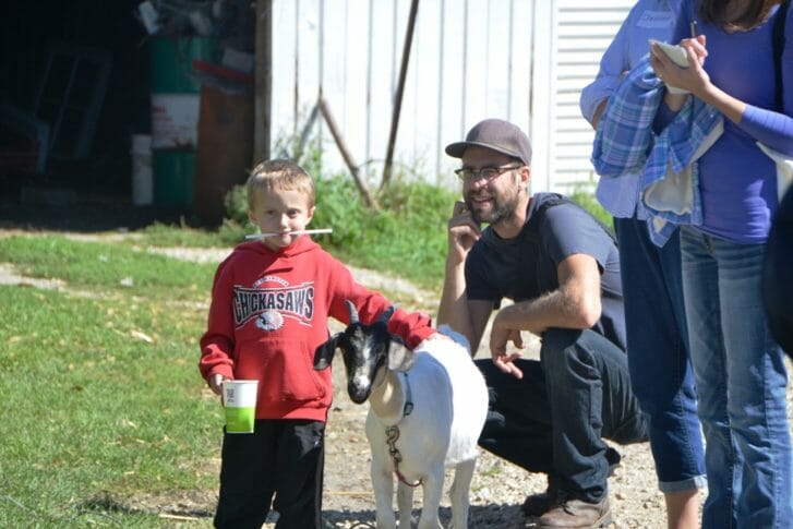 One of the Bagdon boys and Jason Misik hang out with a goat during one stop on the farm tour.