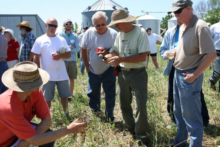 Billy leads a discussion in the field where the soybeans were drilled and the rye was rolled.