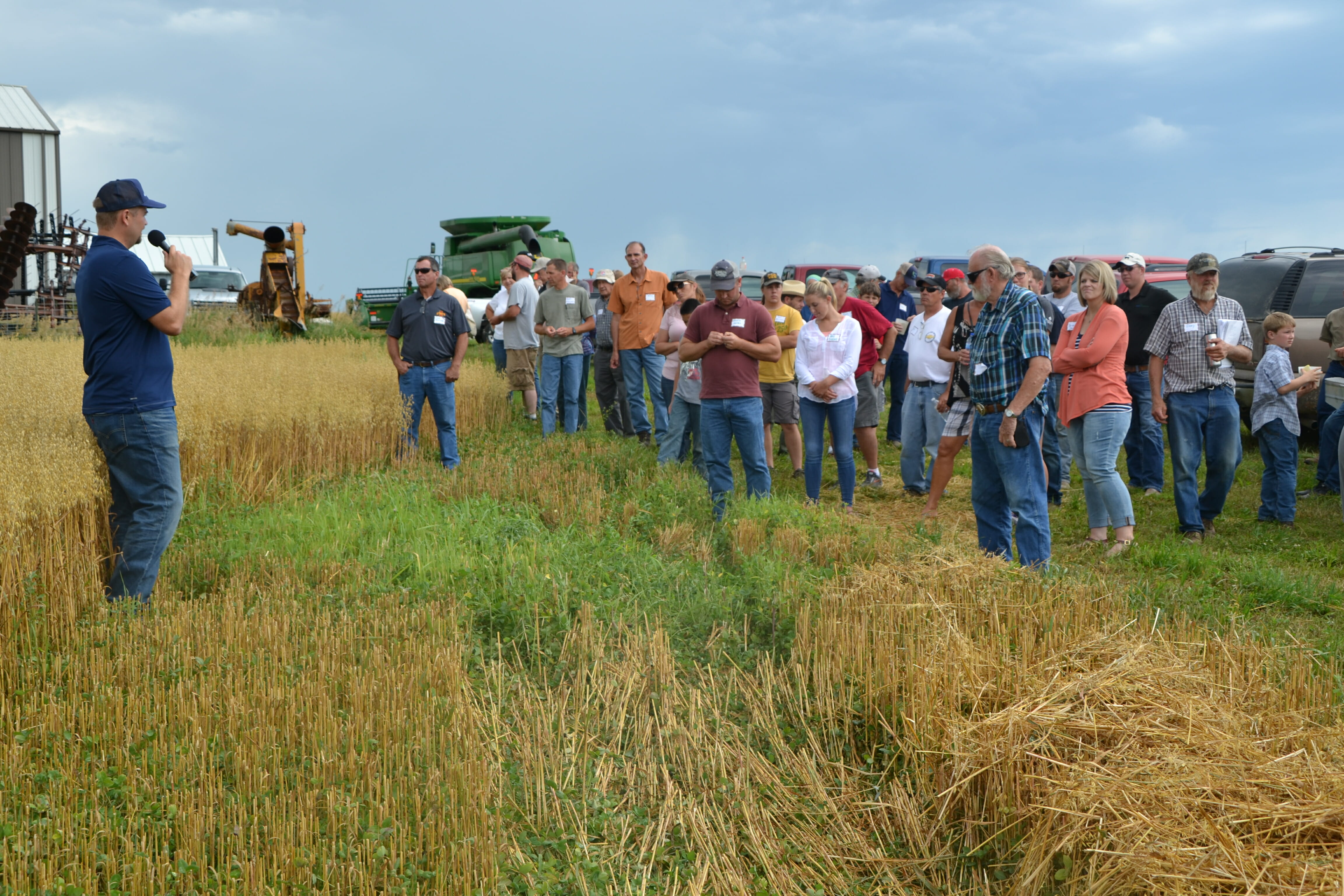 Scott Ausborn (far left) discusses their oat crop with a red clover underseeding.